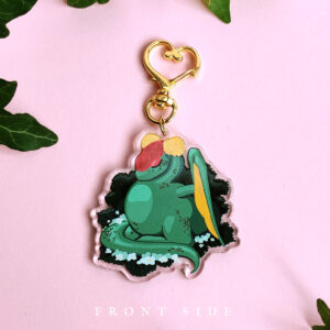 Green daron acrylic charm with a golden heart shaped clasp for hanging.